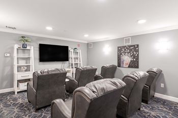 A room with grey chairs and a television.